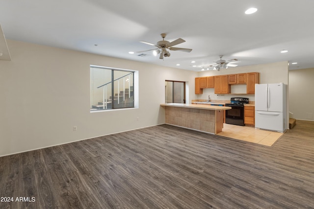 kitchen featuring ceiling fan, light hardwood / wood-style floors, white refrigerator, electric range, and kitchen peninsula