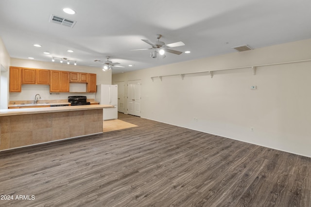 kitchen with kitchen peninsula, light hardwood / wood-style floors, sink, white fridge, and black / electric stove