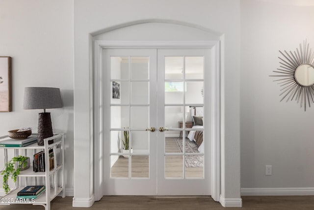 doorway with french doors, wood finished floors, and baseboards