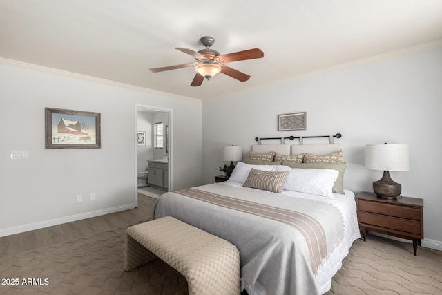 bedroom with crown molding, baseboards, wood finished floors, ensuite bathroom, and a ceiling fan