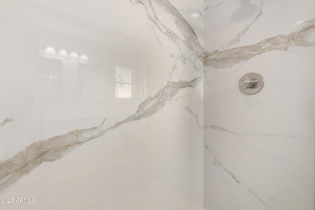 bathroom view of a marble finish shower