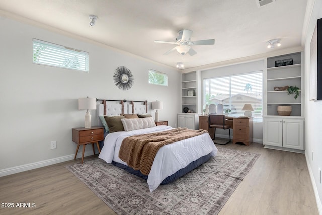 bedroom with light wood finished floors, crown molding, baseboards, and a ceiling fan