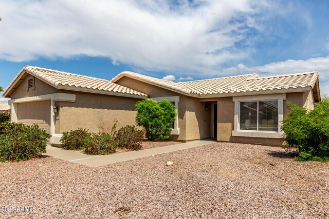 view of front of property featuring stucco siding, a garage, and a tiled roof