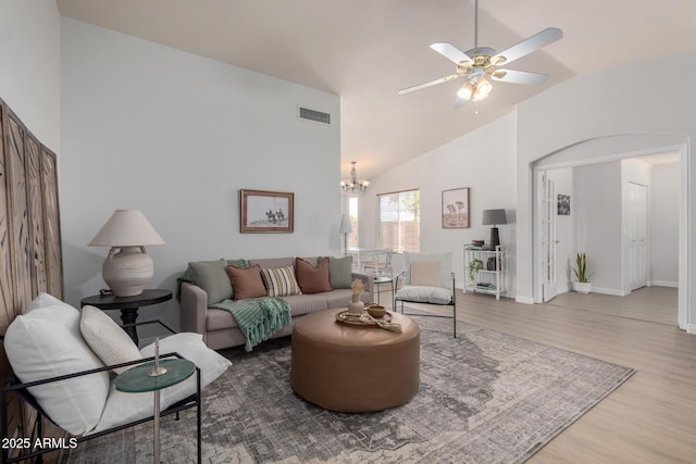 living area with vaulted ceiling, wood finished floors, a chandelier, a ceiling fan, and baseboards