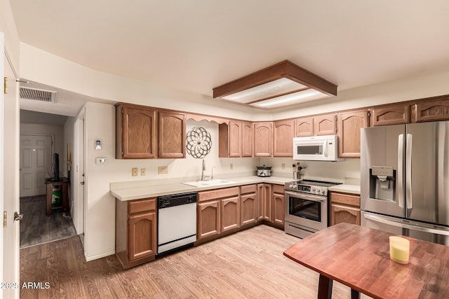 2105 S Zinnia Ave Unit 468, Mesa, AZ 85209 - kitchen featuring appliances with stainless steel finishes, light countertops, and light wood-style floors