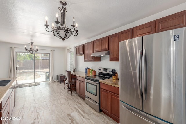 kitchen with pendant lighting, a chandelier, appliances with stainless steel finishes, and a textured ceiling