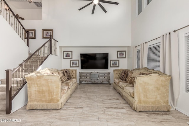 living room featuring a high ceiling and ceiling fan