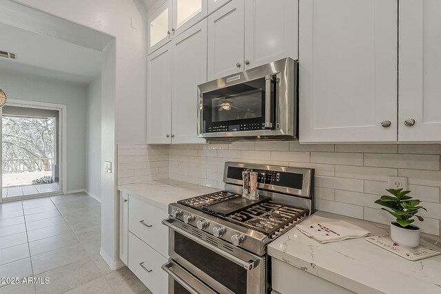 11752 N 135th Pl, Scottsdale, AZ 85259 - kitchen featuring white cabinets, baseboards, appliances with stainless steel finishes, and light stone countertops