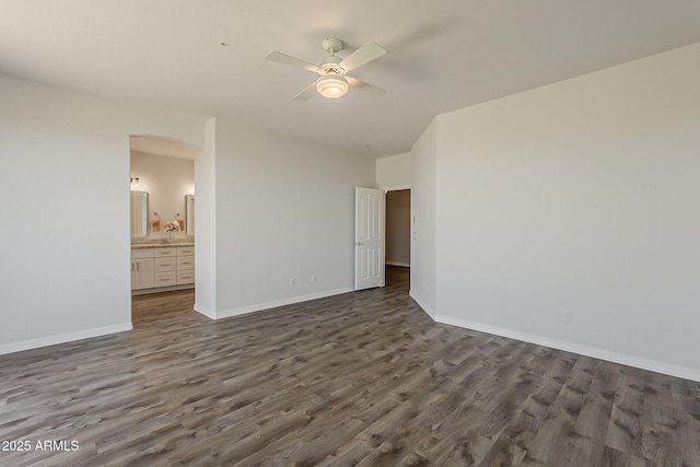 11752 N 135th Pl, Scottsdale, AZ 85259 - unfurnished bedroom featuring dark wood-style floors, a ceiling fan, arched walkways, ensuite bath, and baseboards