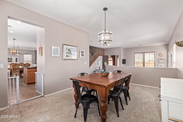 carpeted dining room with an inviting chandelier