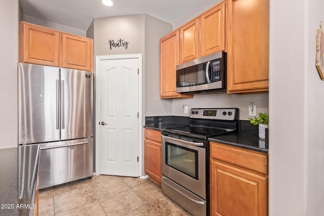 kitchen with stainless steel appliances and dark stone countertops