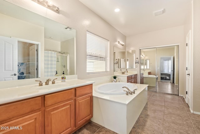 bathroom featuring plus walk in shower, vanity, and tile patterned floors