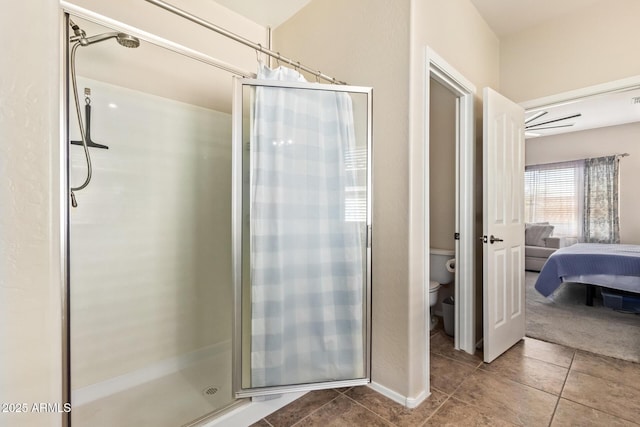 bathroom with toilet, tile patterned floors, and a shower with shower door