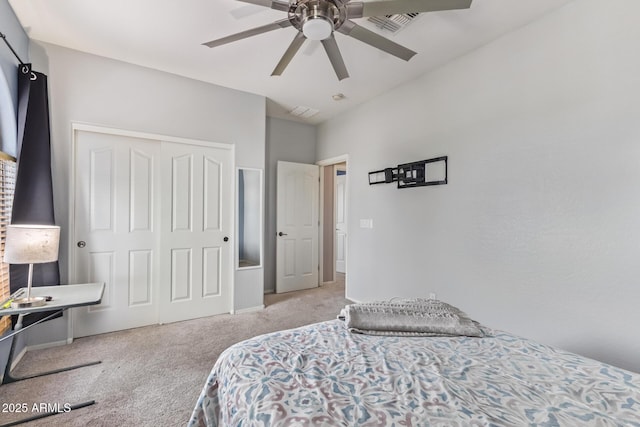 bedroom with light colored carpet, ceiling fan, and a closet