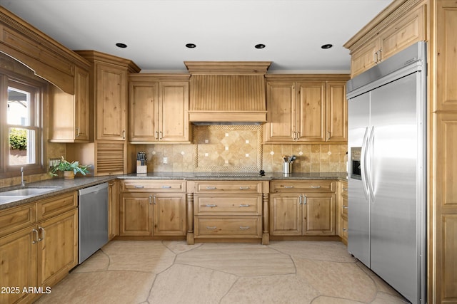 kitchen featuring sink, stainless steel appliances, dark stone counters, and backsplash