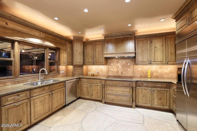 kitchen with custom exhaust hood, decorative backsplash, stone countertops, appliances with stainless steel finishes, and sink