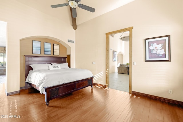 bedroom with ceiling fan, high vaulted ceiling, and hardwood / wood-style flooring