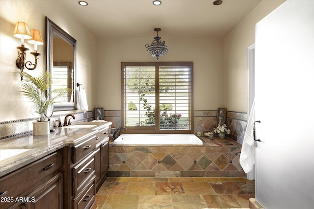 bathroom featuring vanity and tiled bath