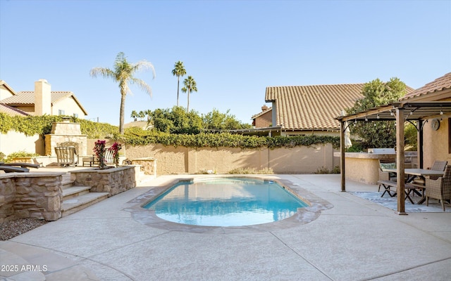 view of swimming pool with an outdoor kitchen, exterior bar, a gazebo, a patio area, and an outdoor stone fireplace