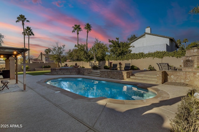 pool at dusk featuring a patio