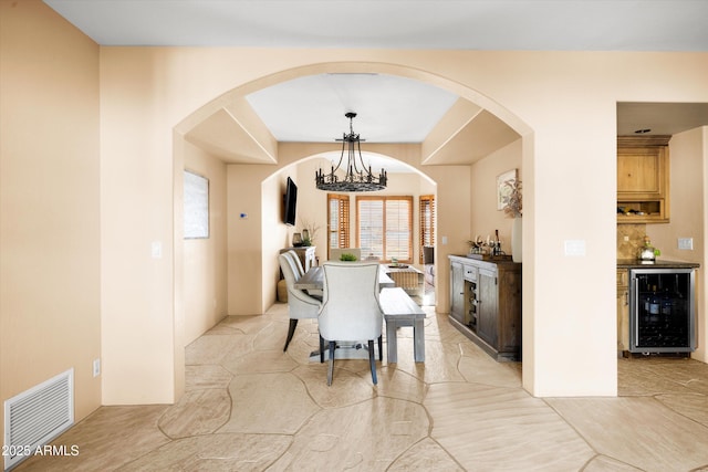 dining area featuring a chandelier and wine cooler