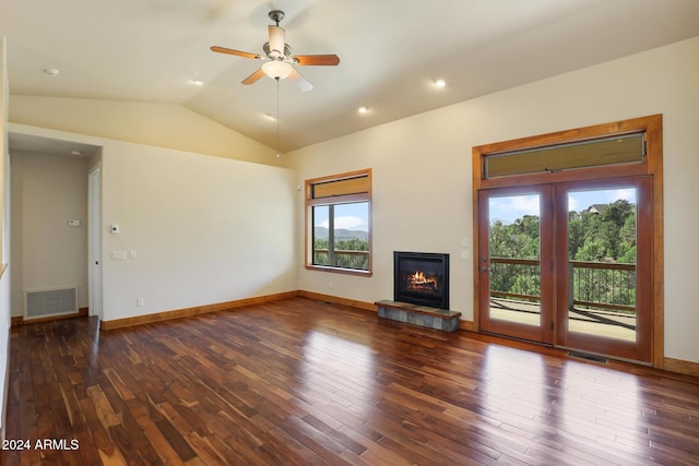 unfurnished living room with a fireplace, lofted ceiling, ceiling fan, and dark wood-type flooring