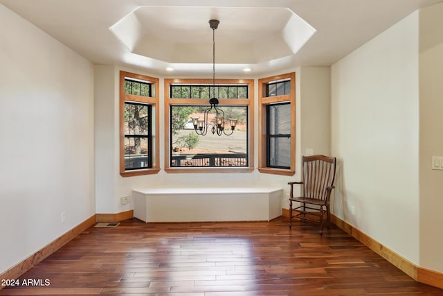 interior space with a chandelier, dark hardwood / wood-style flooring, and a tray ceiling