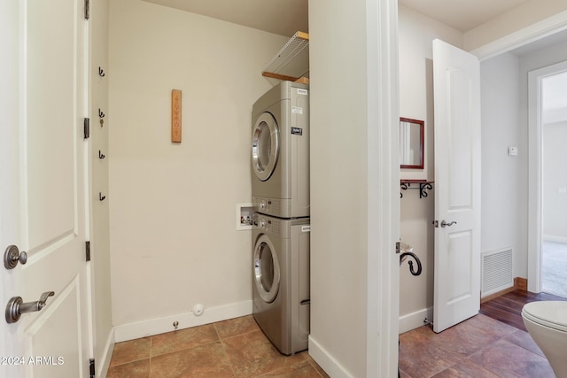 washroom with light tile patterned floors and stacked washer / drying machine