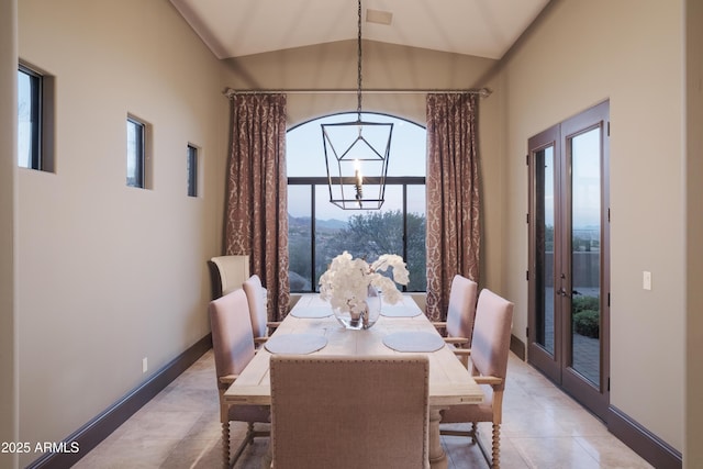 dining area featuring a wealth of natural light, light tile patterned floors, and vaulted ceiling