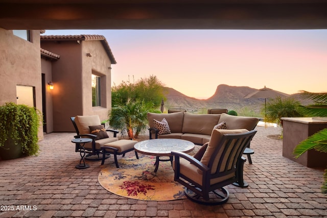 patio terrace at dusk with a mountain view and an outdoor hangout area