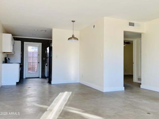 interior space featuring baseboards, visible vents, and concrete floors