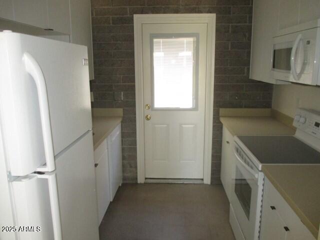 kitchen with white cabinetry, white appliances, and light countertops