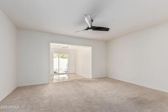 empty room featuring ceiling fan with notable chandelier and carpet