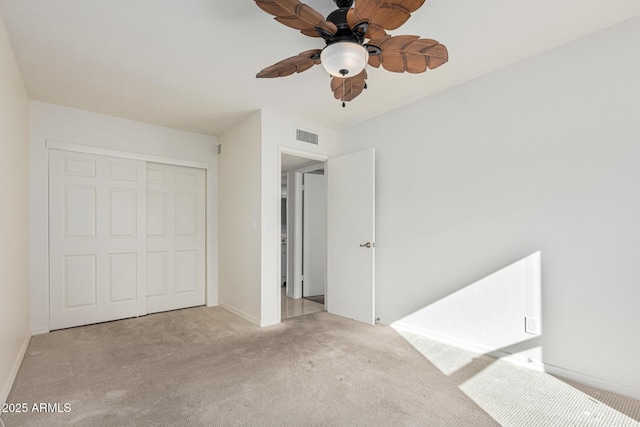 unfurnished bedroom with ceiling fan, a closet, and light carpet