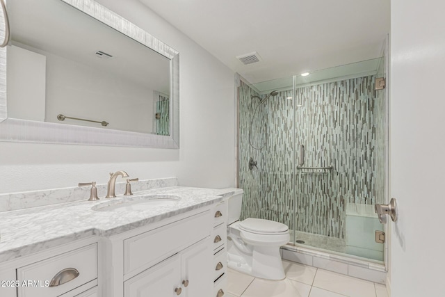 bathroom featuring vanity, toilet, tile patterned flooring, and a shower with door