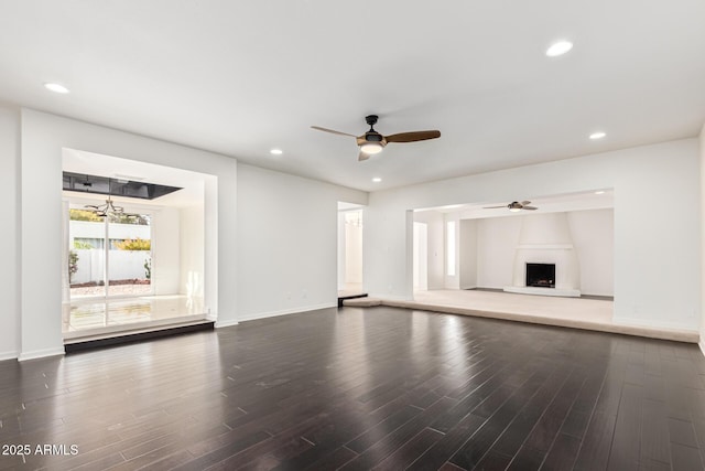 unfurnished living room featuring ceiling fan and dark hardwood / wood-style flooring