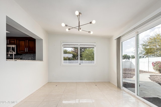 spare room with light tile patterned flooring, a notable chandelier, and vaulted ceiling