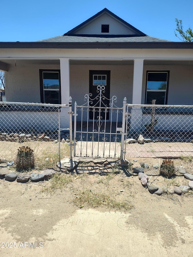 309 W Az Highway 177, Winkelman, AZ 85192 - view of front of house with covered porch, a fenced front yard, stucco siding, and a gate