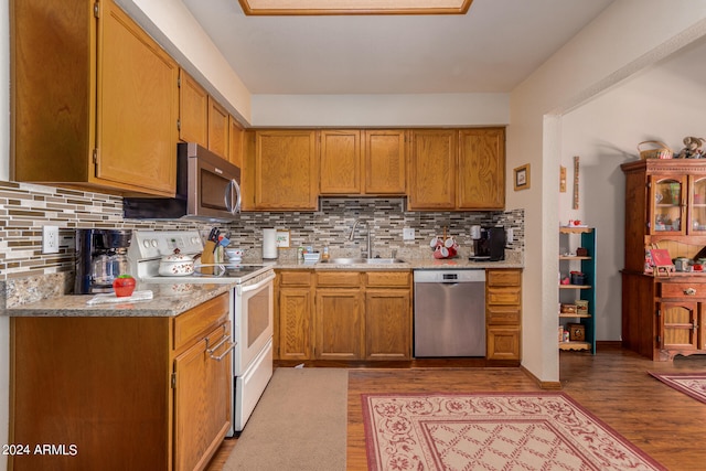 kitchen featuring backsplash, light hardwood / wood-style floors, stainless steel appliances, and sink