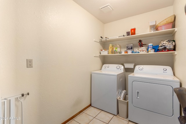 washroom with light tile floors and washer and dryer