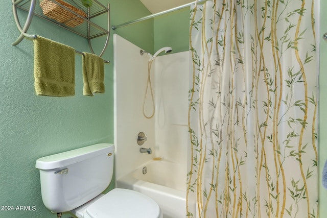 bathroom featuring shower / tub combo with curtain and toilet