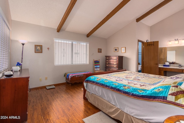 bedroom with lofted ceiling with beams and hardwood / wood-style floors