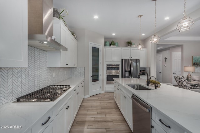 14571 W Wethersfield Rd, Surprise, AZ 85379 - kitchen with appliances with stainless steel finishes, a sink, wall chimney exhaust hood, light wood-type flooring, and backsplash
