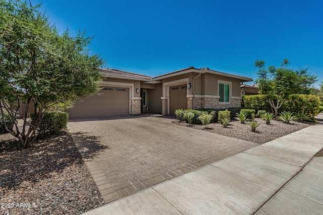 14571 W Wethersfield Rd, Surprise, AZ 85379 - prairie-style home featuring a garage, stucco siding, decorative driveway, and stone siding
