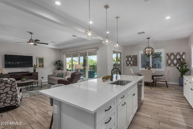 14571 W Wethersfield Rd, Surprise, AZ 85379 - kitchen with a sink, light wood finished floors, stainless steel dishwasher, white cabinetry, and recessed lighting