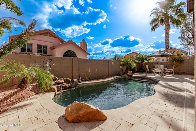 view of swimming pool with a fenced backyard and a patio