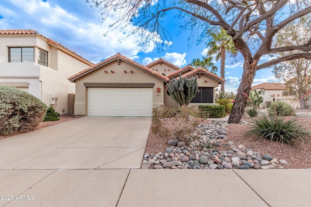 mediterranean / spanish house with driveway, stucco siding, a garage, and a tiled roof