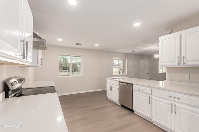 kitchen with a sink, stainless steel appliances, light wood-type flooring, and white cabinets