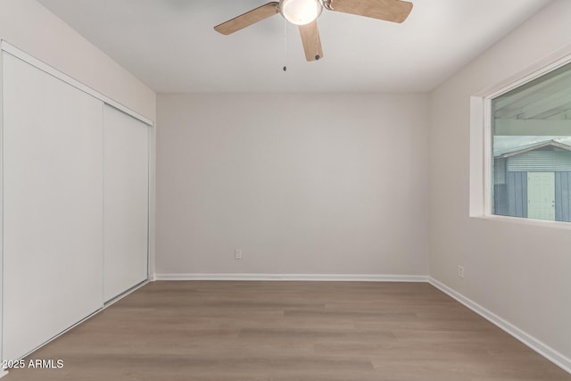 empty room with baseboards, ceiling fan, and wood finished floors