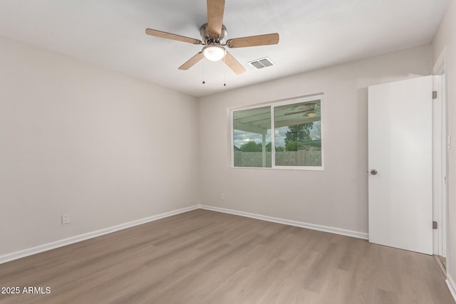 unfurnished room with visible vents, baseboards, wood finished floors, and a ceiling fan